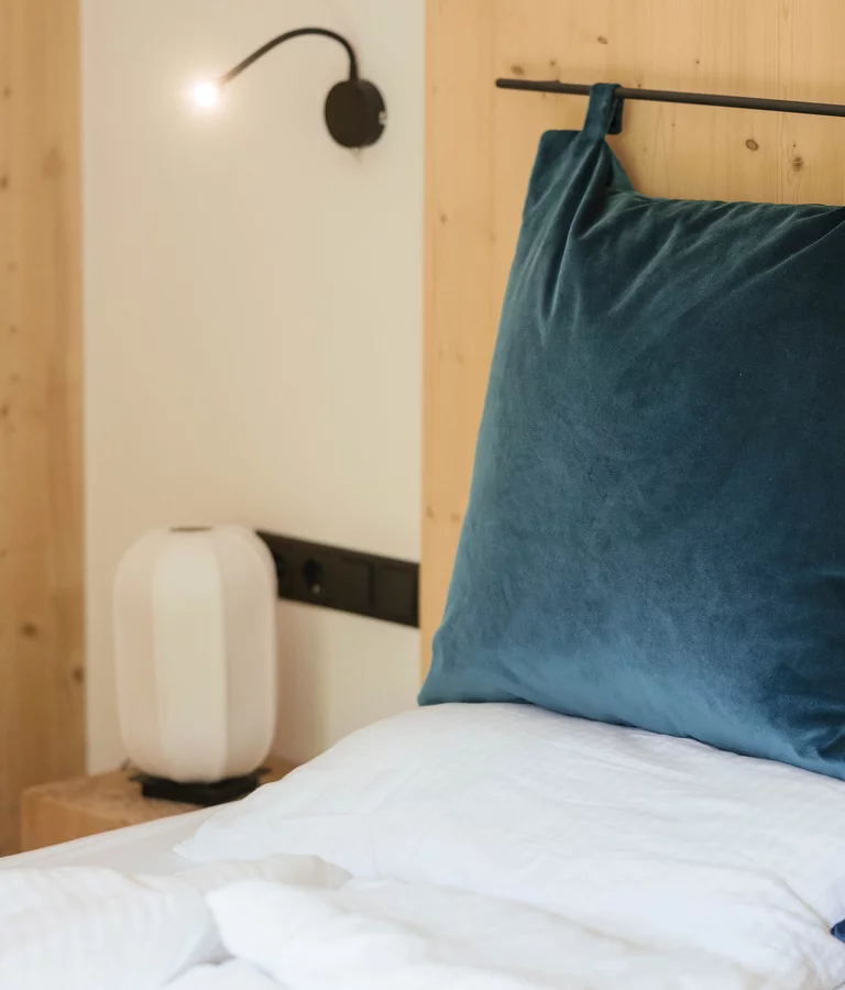 Detail Bett mit blauen Kissen. Ferienwohnung.